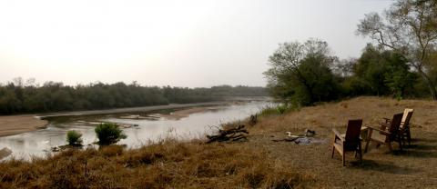 Sundowner with campfire on the banks of the Faro river